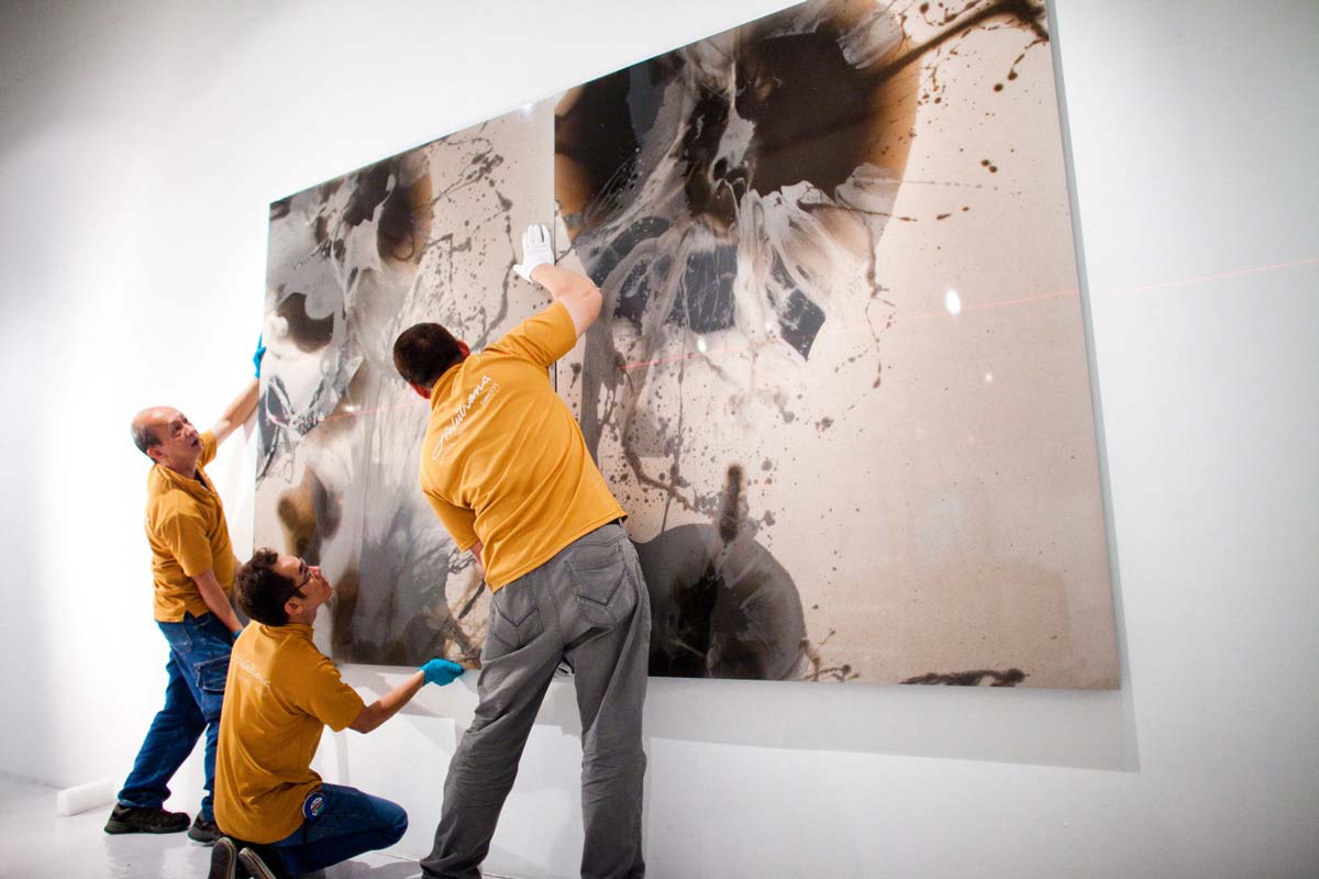 Helu Trans fine art handlers Hanging an artwork on the wall