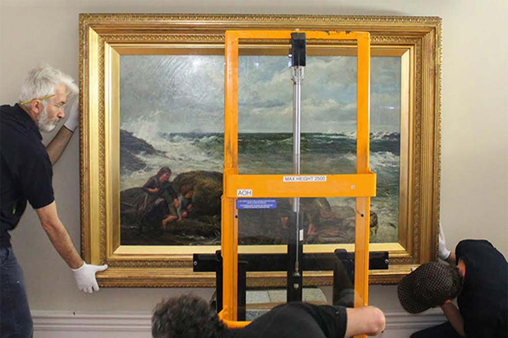 Lotus Fine Art Handlers hanging a piece of fine art